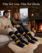 Couple by a chalet fire wearing Kessler heated socks